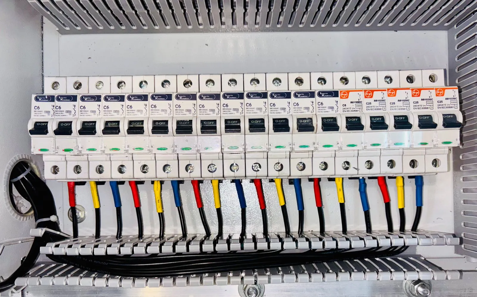 Rangée de disjoncteurs modulaires et de borniers repérés dans un tableau de distribution basse tension