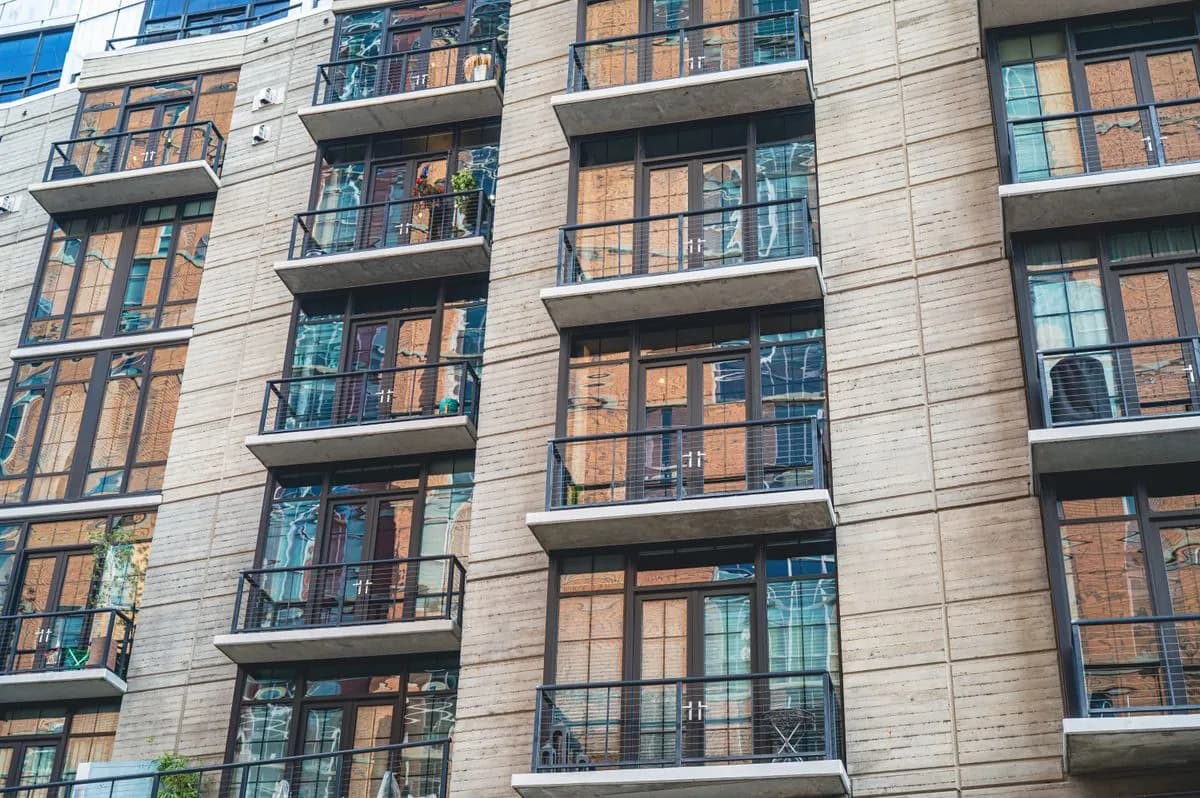 Longue façade d'un ensemble de logements, allées répétées et balcons alignés