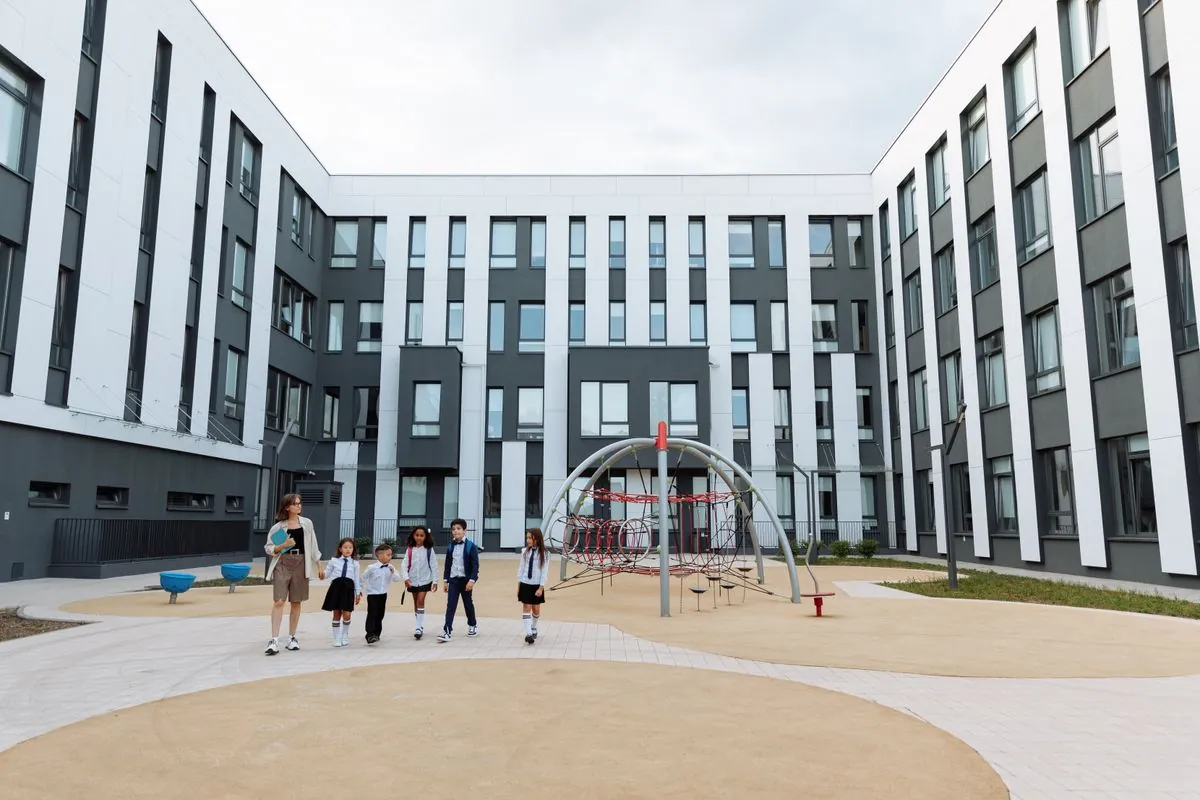 Cour intérieure d'un établissement scolaire contemporain bordée de façades vitrées