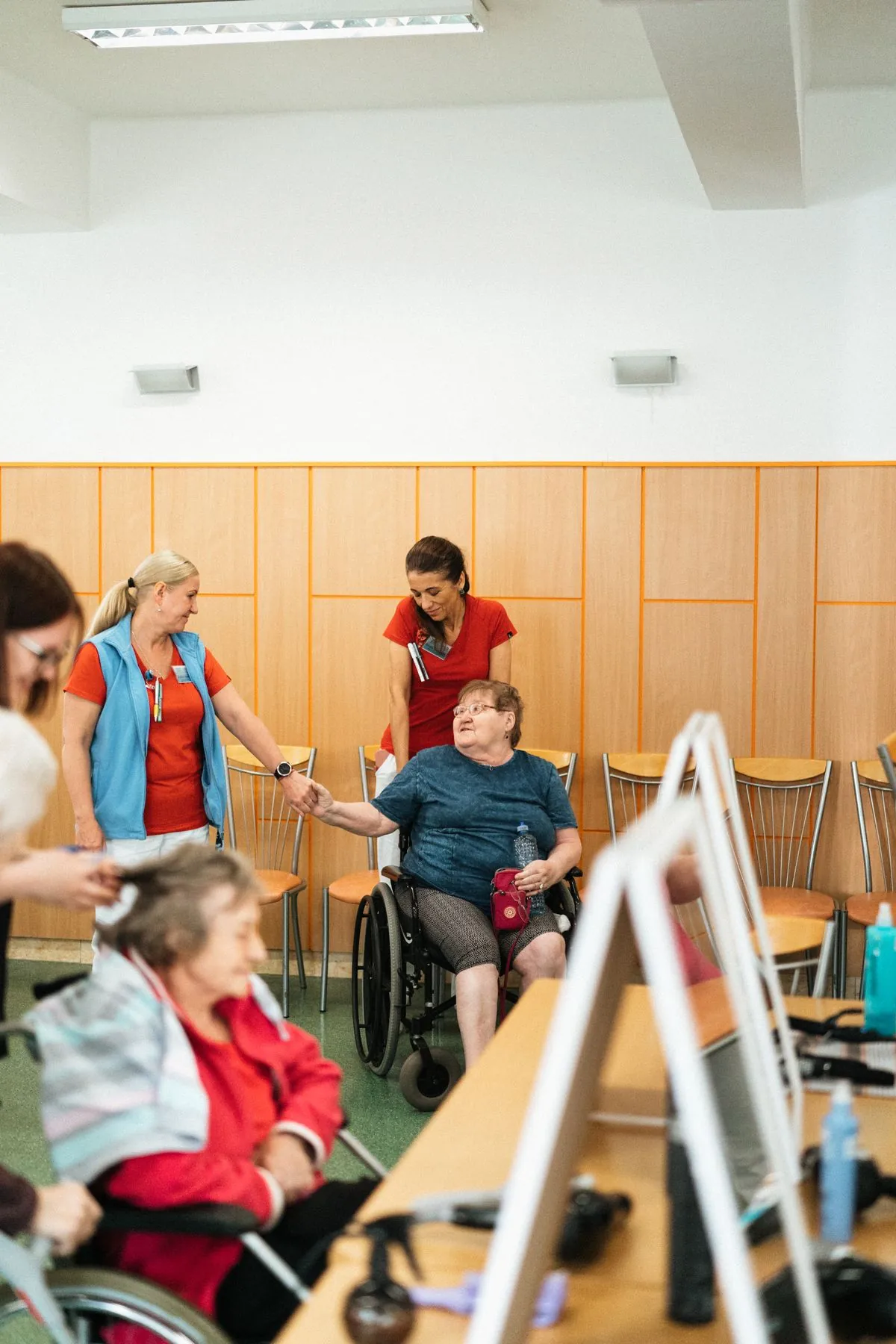 Salle commune d'un établissement médico-social, résidents installés autour des tables