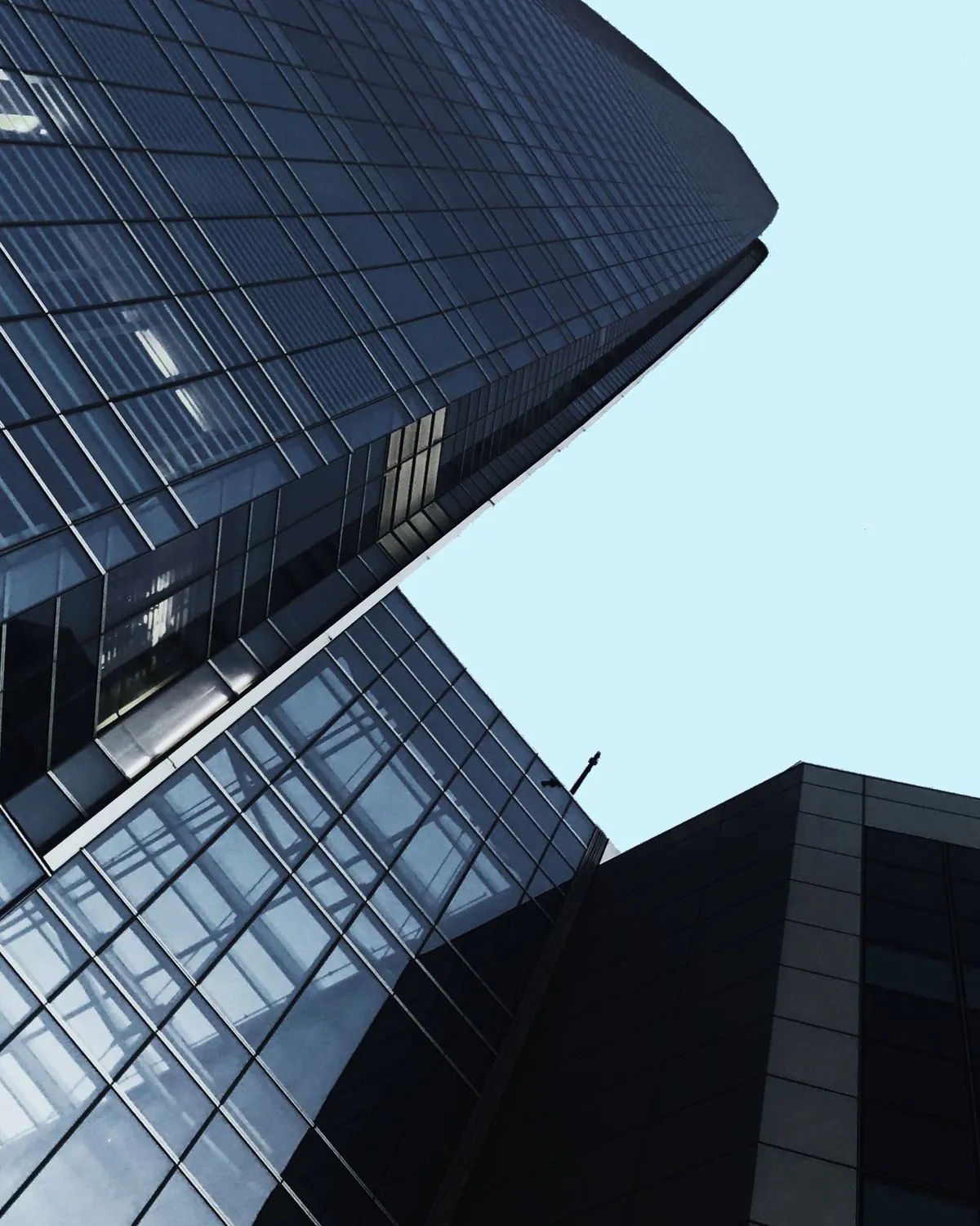 Façade vitrée sombre d'un immeuble de bureaux vue en contre-plongée